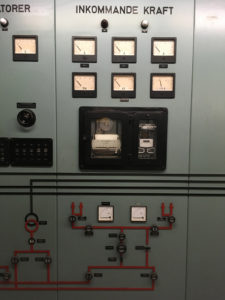 Kontrollpanel i äldre stil. Olika mätare och knappar sitter på panelen. Över dem står "Inkommande kraft".