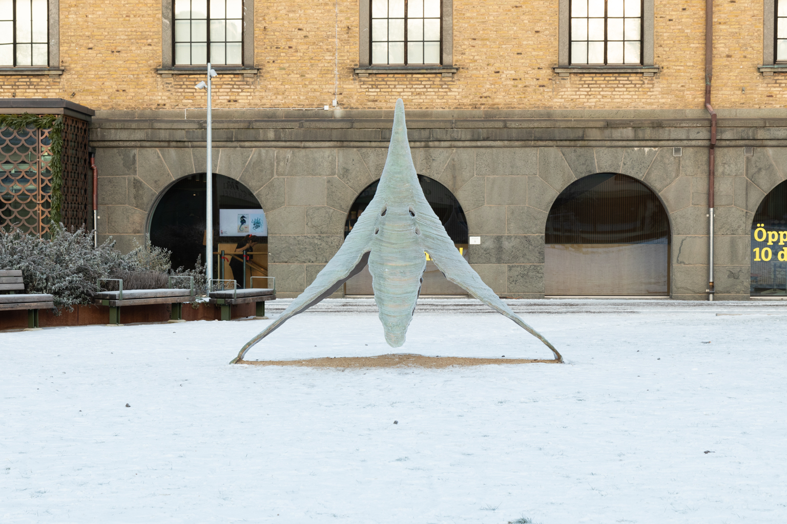 Skulpturen står på en snötäckt mark framför Sjöfartmuseet.